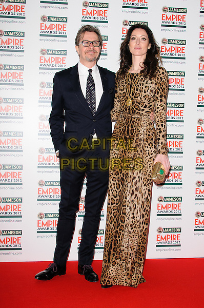 Gary Oldman and Alex Edenborough.The Jameson Empire Film Awards 2012, Grosvenor House Hotel, Park Lane, London, England..March 25th, 2012.full length suit brown dress leopard print married husband wife black white tie glasses goatee facial hair .CAP/CJ.©Chris Joseph/Capital Pictures.