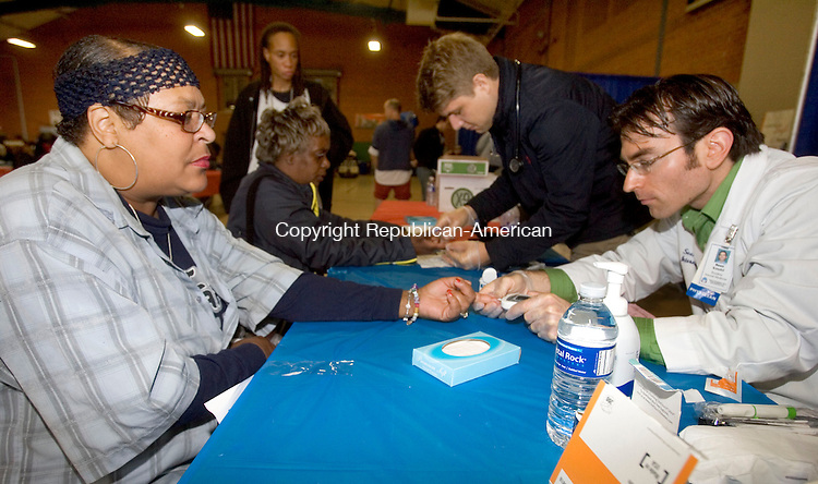 WATERBURY CT. 17 October 2014-101714SV04-From left, Robin Sparkman of Waterbury has her blood sugar checked by Sean Kandel of Waterbury Hospital during the United Way of Greater Waterbury's Project Homeless Connect event at the Armory in Waterbury Friday.<br />
Steven Valenti Republican-American