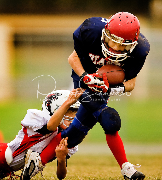 In fall 2009, boys from around Lake Norman, NC, north of Charlotte, pulled on helmets and strapped on pads to play American football, one of the country's most popular sports. The Pop Warner football league has been helping youngsters play the sport since 1929. Photo is part of a series of images documenting one team of North Carolina boys learning and playing the sport in Cornelius, NC in fall 2009. They're playing in the Lake Norman Giants league.
