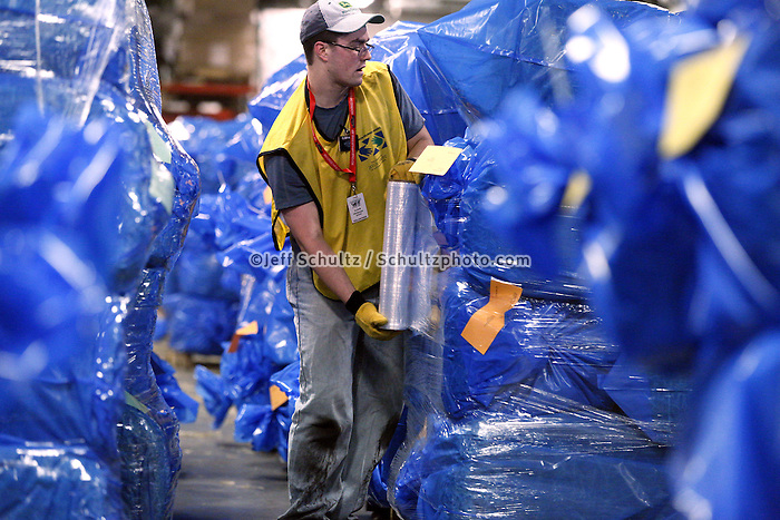 Wyatt Hickman of Black Foot, Idaho plastic wraps some of 1500 bales of straw at Airland Transport in Anchorage to be sent out to the 22 checkpoints along the Iditarod trail Thursday, Feb. 7, 2013. Hickman is volunteering through the Helping Hands ministry, part of the LDS church.
