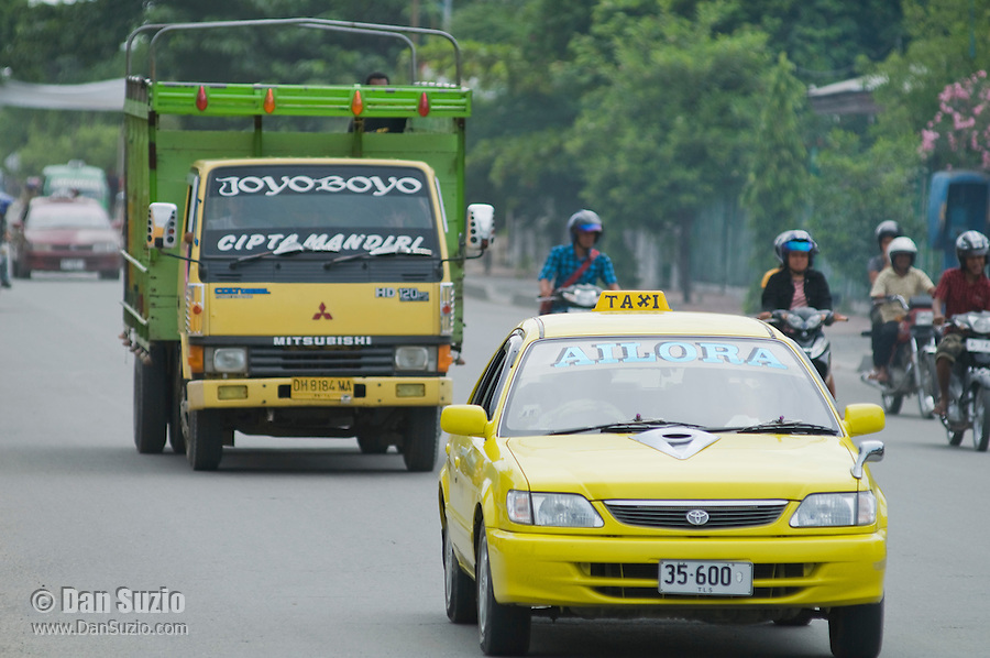Traffic on a busy street in Dili, Timor-Leste (East Timor). Owners of taxis, trucks, and other vehicles give them names and often elaborate paint jobs to attract customers.