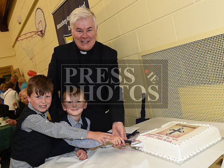 Canon Peter Murphy who was celebrating 40 years in the priesthood cuts his cake with his nephews James and Martin Murphy. Photo:Colin Bell/pressphotos.ie
