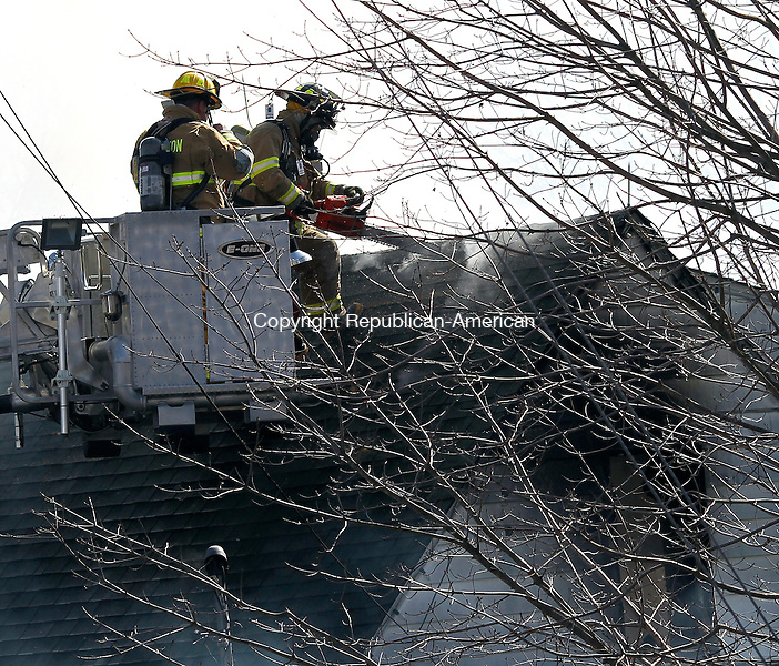 Thomaston, CT-26 March 2012-032612CM02- Firefighters cut a hole on on the roof at the residence on the corner of High Street Ext and Mason Hill where a fire broke out Monday afternoon in Thomaston. Christopher Massa Republican-American