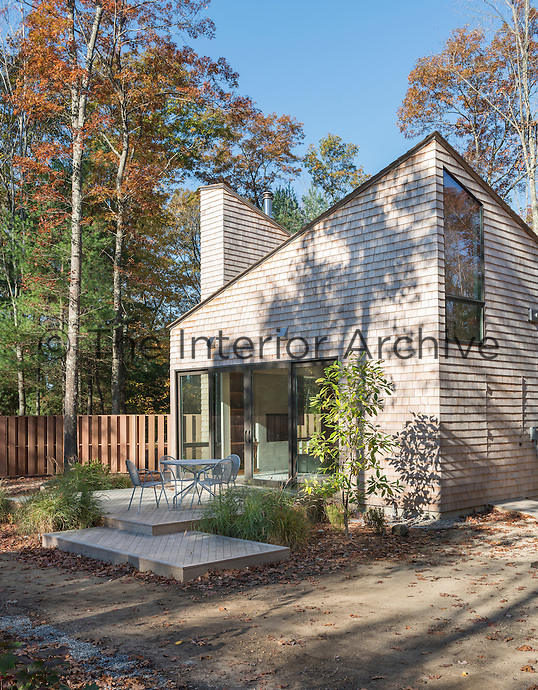 The exterior of a modern cedar wood cottage in New England woods, USA