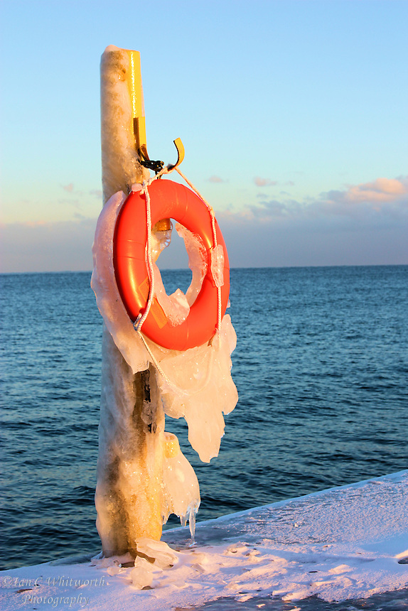 A wintery view of a life preserver on the lighthouse pier in Oakville, Ontario