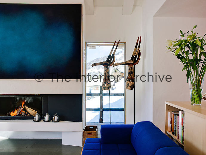 In keeping with the ultra modern interior of the chalet, the fireplace has been enhanced with a bold piece of modern art