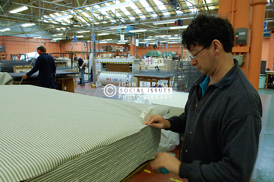 Remploy factory; Forest Hall; Newcastle; UK 2007, Remploy provides specialist employment services to disabled people and those who face barriers to employment, Man making mattress stitching down edging