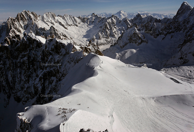 Skiers at the top of Aguille du Midi (12,602 feet or 3842 meters)must rope together to get to get to the starting point for a panaramic top view of the top of Mont Blanc. Mountains guides assist the difficult terrain for the long ski down the mountain. Mont Blanc is the highest mountain in the Alps--4807 meters.