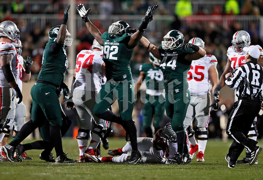Michigan State Spartans defensive lineman Joel Heath (92) celebrates a sack of Ohio State Buckeyes quarterback J.T. Barrett (16) during the first quarter of the NCAA football game at Spartan Stadium in East Lansing, Michigan on Nov. 8, 2014. (Adam Cairns / The Columbus Dispatch)
