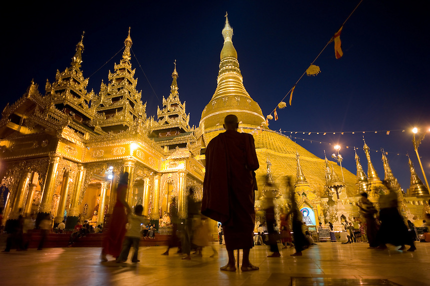 An elderly monk meditates before the historic Shwedagon Paya, Yangon, Unuon of Myanmar (Burma), Nov. 26, 2009. The Shwedagon pagoda's central hti, an umbrella spire atop the giant zedi structure, sports a 76-karat diamond that casts red, green white beams to specific spots on the terrace as the sun rises or sets. The massive complex sits atop a 190-foot hill accessed by four stair-stepped walkways guarded by 30-foot-tall mythical half-lion half-dragon creatures called chinthe. The central 98-foot-tall zedi is surrounded by an incredible assortment of other smaller zedi, statues and temples...EDS: Not for syndication nor redistribution. Web slide show only. Please do not strip metadata for Web use.