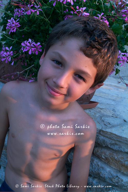Young boy in a garden at sunset, France.