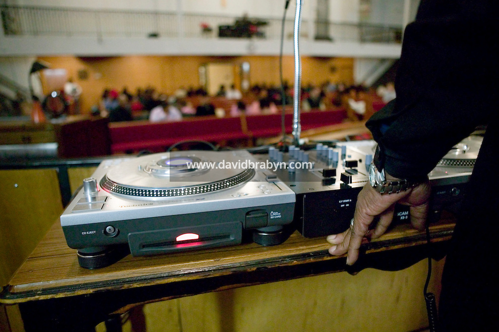 New York, USA - Hip-hop pioneer Kurtis Blow (R, partially hidden) mans the turntables during mass at the Greater Hood Memorial AME Zion Church, home of the Hip-Hop Church, in Harlem, New York, USA, 17 February 2005. Photo Credit: David Brabyn.