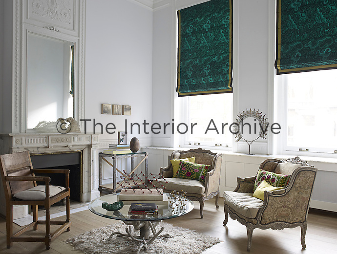 A pair of Marquise-style armchairs make a statement amidst the eclectic furnishings of the living room