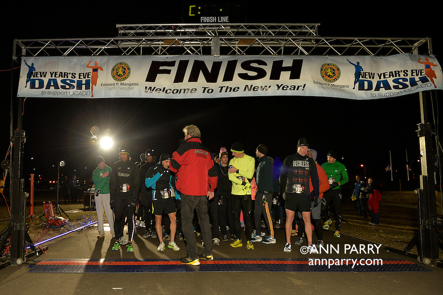 East Meadow, New York, USA. December 31, 2014. Runners wait until the stroke of twelve midnight at the Start Line Finish Line at the 5K New Year's Eve DASH to support the Long Island Council on Alcoholism and Drug Dependence (LICADD) at the Twin RInks Ice Center at Eisenhower Park in Long Island. A Skatin' New Year's Eve event started hours earlier and a New Year's Eve Party, open to runners, family and friends continued until 2:30 a.m.