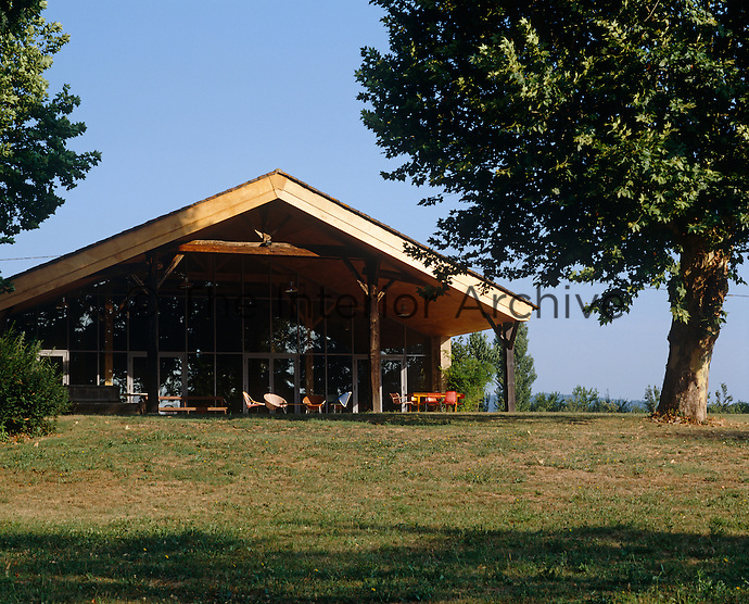 The chairs on the terrace take advantage of this contemporary barn's views over the River Lot