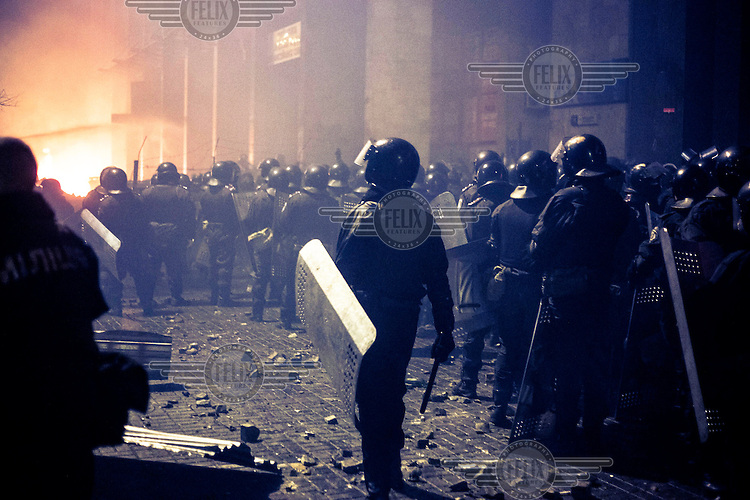 Riot police officers with shields and helmets gather near Maidan Nezalezhnosti (Independence Square), renamed EuroMaidan by protesters since November 2013. Protests against the government of President Viktor Yanukovych were sparked on 21 November 2014 by the Ukrainian government's decision to suspend preparations for the signing of an association agreement with the European Union that would have increased trade with the EU. Some believe that the U-turn came about as a result of pressure from President Putin of Russia who wants Ukraine to join a customs union with itself, Kazakhstan and Belarus. Russia offered 15 billion dollars of soft loans and reduced price gas to Ukraine at the same time as discussions with the EU were taking place. After weeks of protests and a number of deaths, Prime Minister Mykola Azarov and the entire cabinet resigned. Protesters are holding out, however, for President Yanukovych to resign and continue to occupy public buildings and squares to put pressure on the president. On 18 February, after Yanukovych's party scuppered a move to change the constitution to reduce the powers of the president, renewed fighting between protesters and police broke out and had cost the lives of around 80 people by Friday 21st February.