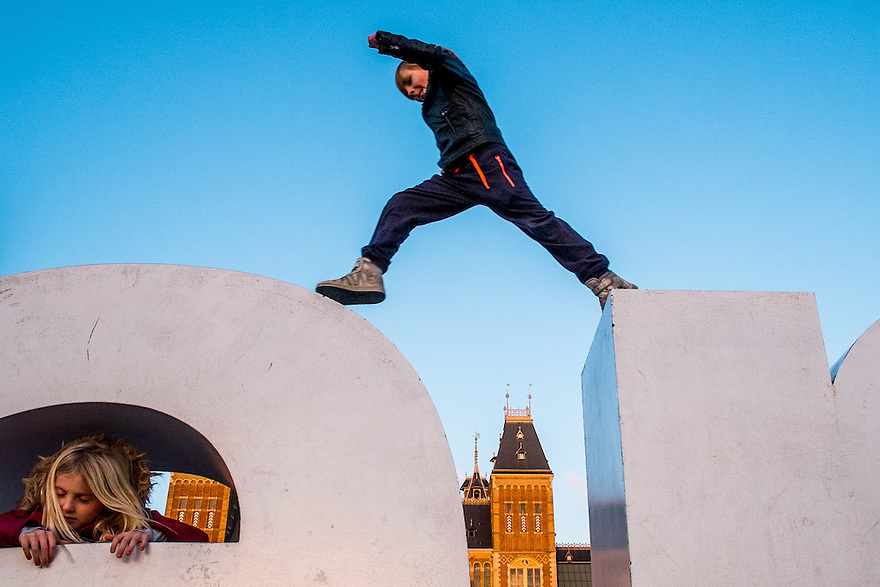 Nederland, Amsterdam, 4 jan 2015<br />
Kinderen springen over de letters van het Amsterdam Logo I Amsterdam op het museumplein. Daarachter het Rijksmuseum<br />
<br />
<br />
Foto: (c) Michiel Wijnbergh