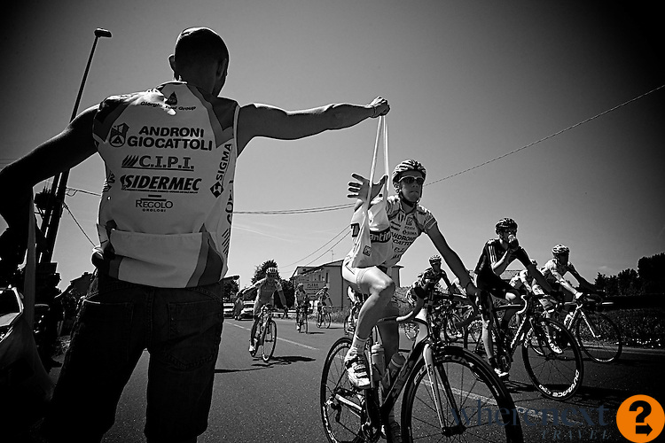 2:13 pm feed zone -- 90 kms into the day, soigneurs deliver carefully packed bags with: one energy gel pack, three small jam-filled muffins, one coconut energy bar, one fruit-flavored protein bar, and two multi-dextrin energy drinks.