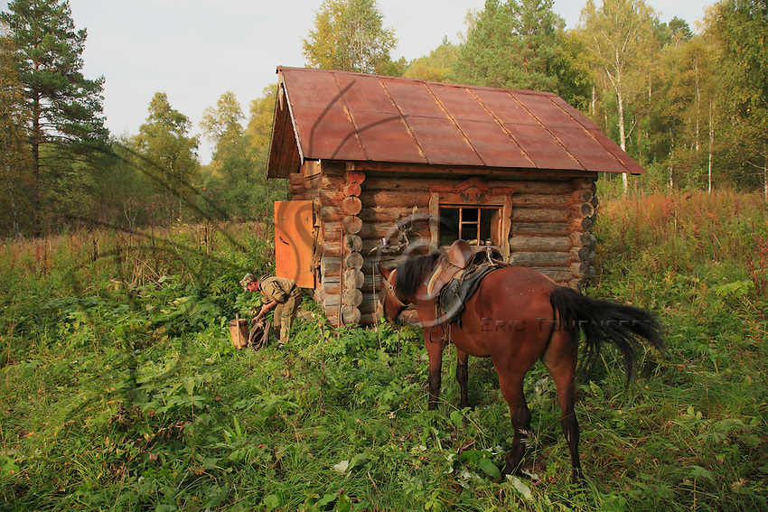 Sabit Galin unloads his horse and sets up the necessary for a night in one of the reserve’s cabins.