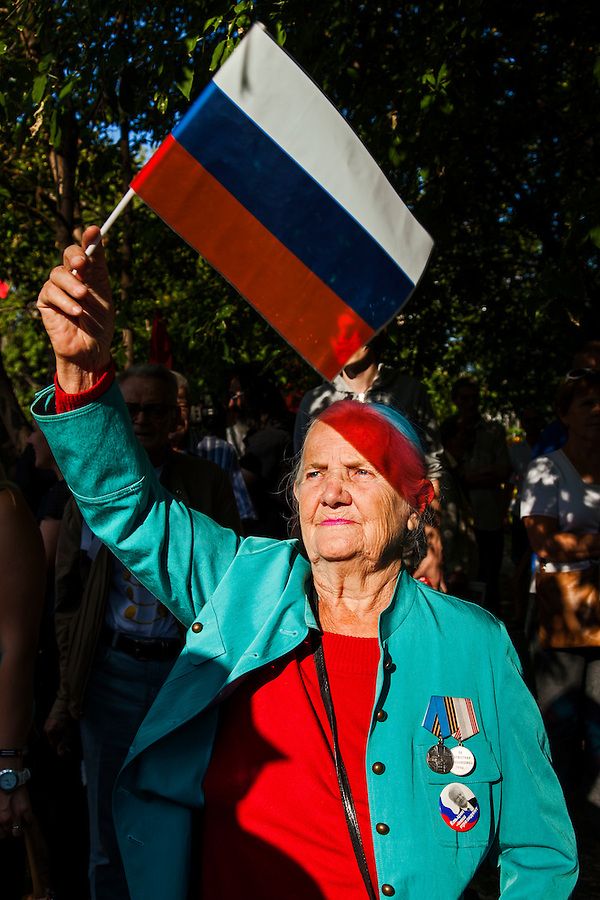 Moscow, Russia, 19/08/2012..A woman wearing a Boris Yeltsin badge waves a Russian flag at an opposition rally. Several hundred opposition demonstrators gathered near the Russian government White House to mark the 21st anniversary of the attempted coup in 1991 by Communist hardliners that led to the eventual break-up of the Soviet Union.