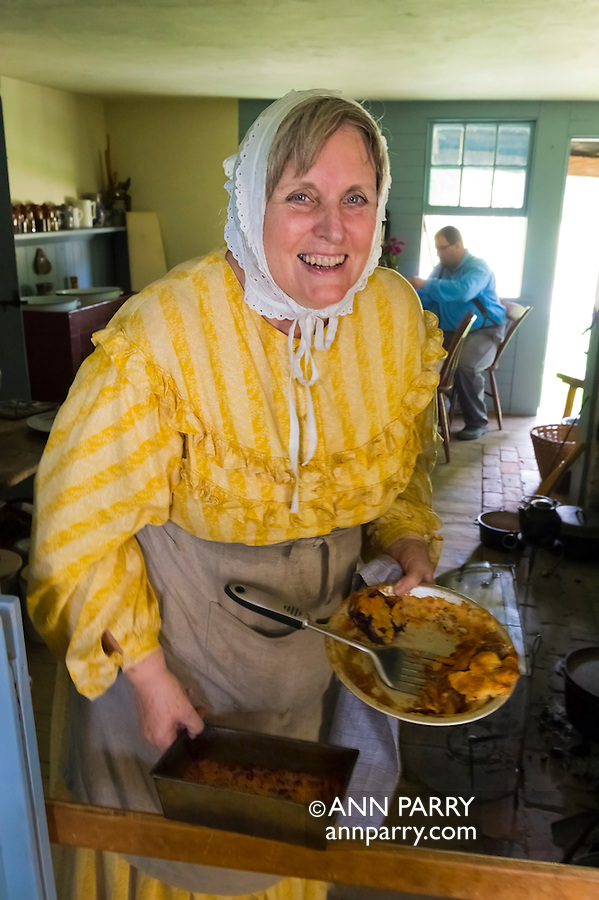 Old Bethpage, New York, U.S. 31st August 2013. CHERLY BLAM of Cedarhurst is holding pie and other baked goods she and other volunteers made during the Olde Time Music Weekend at Old Bethpage Village Restoration. The yellow dress and white lace hat she is wearing are American Civil War era clothing of the 1800's.