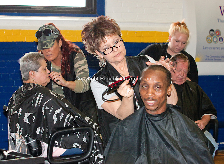 TORRINGTON CT- APRIL 22 2015 042215DA01- Army veteran Guerino Magloire of West Haven receives a free haircut from Diane Gioia of the Hair Dr. in Torrington during the fourth annual Stand Down for Veterans held at the Torrington Armory on Wednesday. The event brought a variety of services to help veterans statewide who are homeless or in need. More than two dozen organizations were on hand. The agencies, programs and services available for veterans in need included the federal Department of Labor, the Social Security Administration, Connecticut Legal Services, higher education, mental health and addiction services, social services, transportation and hair care.<br />
Darlene Douty Republican American