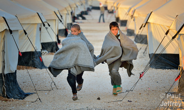 Early in the morning, boys run amid the tents in the Zaatari Refugee Camp, located near Mafraq, Jordan. Opened in July, 2012, the camp holds upwards of 50,000 refugees from the civil war inside Syria, but its numbers are growing. International Orthodox Christian Charities and other members of the ACT Alliance are active in the camp providing essential items and services.