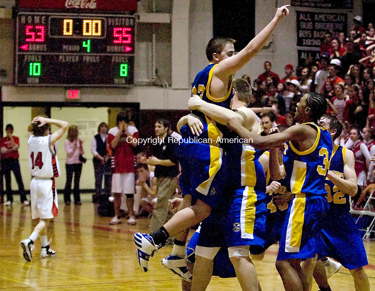 TORRINGTON--12 January 07--011208TJ09 - Gilbert teammates lift Jim Bunnel (23) in the air as Northwestern's Brian Terwilliger (14), at left, walks off the court after the buzzer sounds, securing The Gilbert School's 55-53 win against Northwestern Regional High School at Torrington High School on Saturday, January 12, 2008. (T.J. Kirkpatrick/Republican-American)