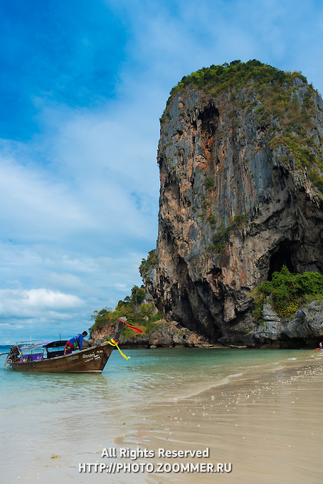 Longtail boat near a rock on Phra Nang beach in Krabi, Thailand