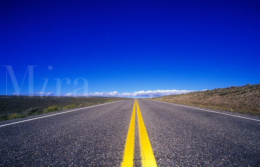 USA, Utah, road leading to horizon in the desert with bright yellow markings