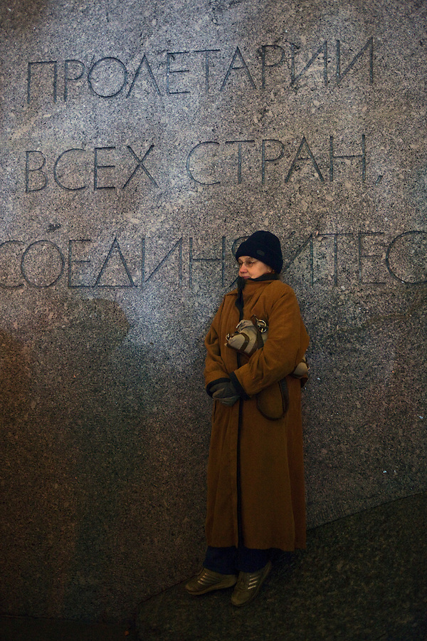 Moscow, Russia, 28/10/2011..A woman watching the gala reopening of the Bolshoi Theatre on a giant video screen while standing on the plinth of a statue of Karl Marx with the inscription “Workers of the world unite”. The theatre had been closed since 2005 for reconstruction work that cost some $700 million.