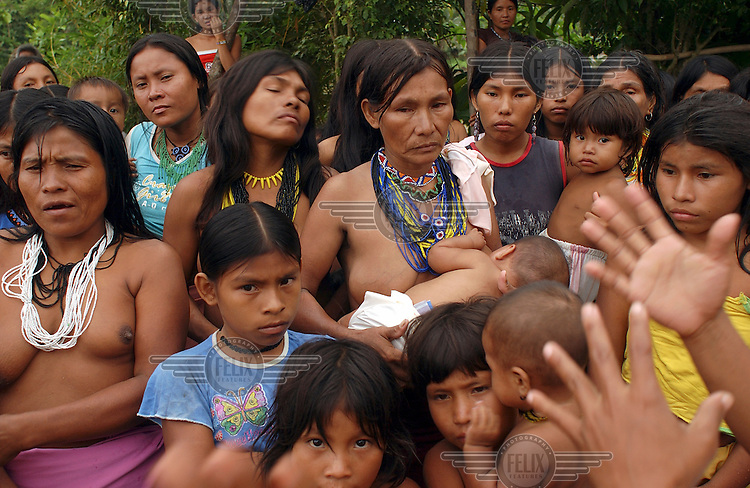 Ethnic Wounaan women and children attend a community meeting. The woman feeding the baby says "after what happened in the community I feel really scared to return. I even feel scared here because this place is so strange to us." They fled their ancestral homes when FARC (Revolutionary Armed Forces of Colombia) killed two of their community leaders and attempted to contol their tribe and recruit their children. After 40 years of civil unrest, Colombia has the world's third highest displaced population due to conflict. ..Photo: Dermot Tatlow/Panos Pictures/Felix Features