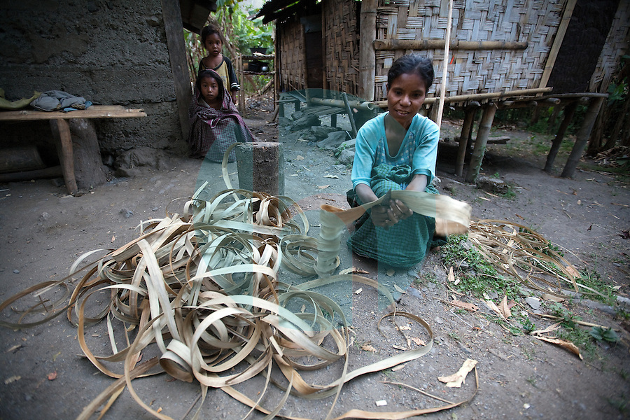 A woman uses the skin from a particular kind of local tree to weave ropes, which farmers will later use to look after their animals in the mountain town of Laclubar, Timor-Leste on Wednesday, Oct. 19th, 2011. Photographer: Daniel J. Groshong/The Hummingfish Foundation