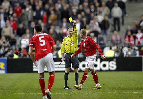 26 March 2008: England midfielder David Beckham, making his 100th appearance for England, is booked by German referee Florian Meyer during the International Friendly game between France and England, played at Stade de France, Paris. France won the game 1-0. Photo: Neil Tingle/Actionplus....080326 football soccer player yellow card