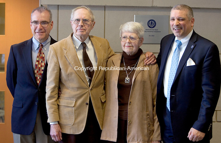 WATERBURY CT. 13 April 2015-041315SV07-From left, Mitchell Green, professor, David and Joan Reed of Middlebury and William Pizzuto, Director of Waterbury UConn, stand by a plaque stating the David and Joan Reed Faculty Fellowship Endowment outside the community room at the school in Waterbury Monday. <br />
Steven Valenti Republican-American