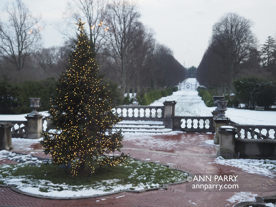 Old Westbury, New York, USA. December 17, 2017. Old Westbury Gardens musem, a former estate of John Shaffer Phipps, welcomes visitors during snowy winter holiday weekend. Westbury House rooms had lit fireplaces, and were decorated with Christmas Trees, a train set in bedroom, deer family watching doe take bubble bath in bathroom, and more festive decorations. Cider and cookies were served in large sunroom.