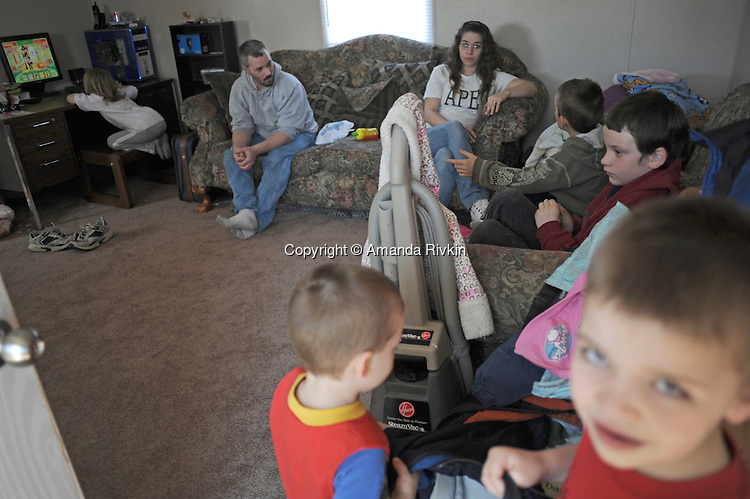 Terry and Desiree Gonyon with five of their nine children (clockwise from top left) Aedily, 7, Tylar, 7, Michael, 9, Kyle, 6, and Zachary, 3, at home in a self-described combined household "like the Brady Bunch," after they lost their home in nearby Elkhart, Indiana to foreclosure in the Timber Brook Mobile Home Park in Bristol, Indiana on April 8, 2009. Two children were in Indianapolis for the day with relatives and friends and the oldest went to live with her mother.
