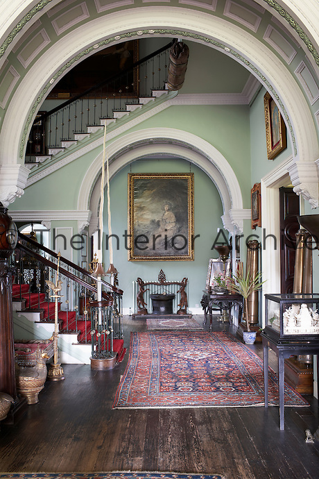 Inside the house on the Clandeboye estate, which is the home to Lady Dufferin, Marchioness of Dufferin and Ava. The staircase, flanked by a pair of Icelandic narwhal tusks and decorated with artefacts collected in East Asia, all souvenirs from travels by the 1st Marquess.