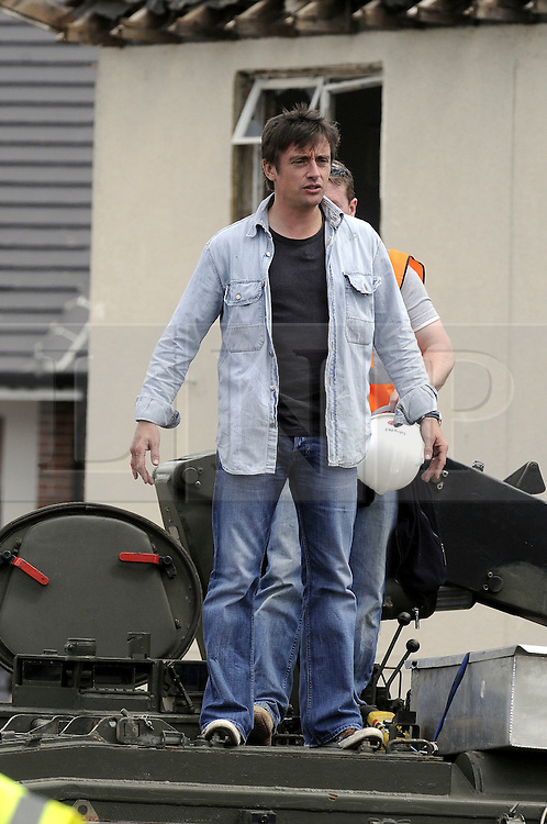 © licensed to London News Pictures. 01/07/2011. Gravesend, Kent. Jeremy Clarkson breaks the the water mains with the remote controls of the Armtrac tank type vechicle. Top Gear presenters Jeremy Clarkson, James May and Richard Hammond smashing up old houses in Gravesend, Kent with tanks during filming for Top Gear today (01/07/2011). See special instructions. Photo credit Grant Falvey/LNP.
