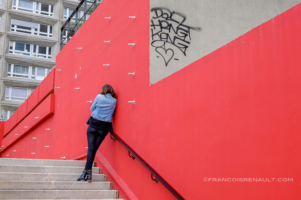 La Dalle Tolbiac, 13 ème arrondissement, Paris. Une femme contre un mur rouge. / The Dalle Tolbiac 13th arrondissement, Paris. A woman against a red wall.