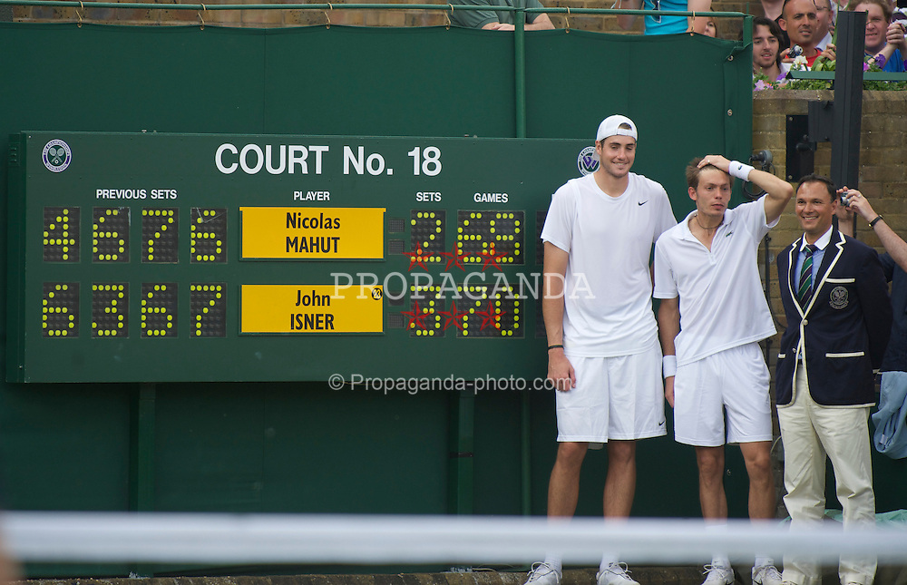 LONDON, ENGLAND - Thursday, June 24, 2010: John Isner (USA) poses with Nicolas Mahut and Umpire Mohamed Lahyani next to the scoreboard after the historic longert game ever that lasted 11 hours and five minutes over three days. He beat Nicolas Mahut with the final score of 6-4 3-6 6-7 (7-9) 7-6 (7-3) 70-68 on day four of the Wimbledon Lawn Tennis Championships at the All England Lawn Tennis and Croquet Club. (Pic by David Rawcliffe/Propaganda)