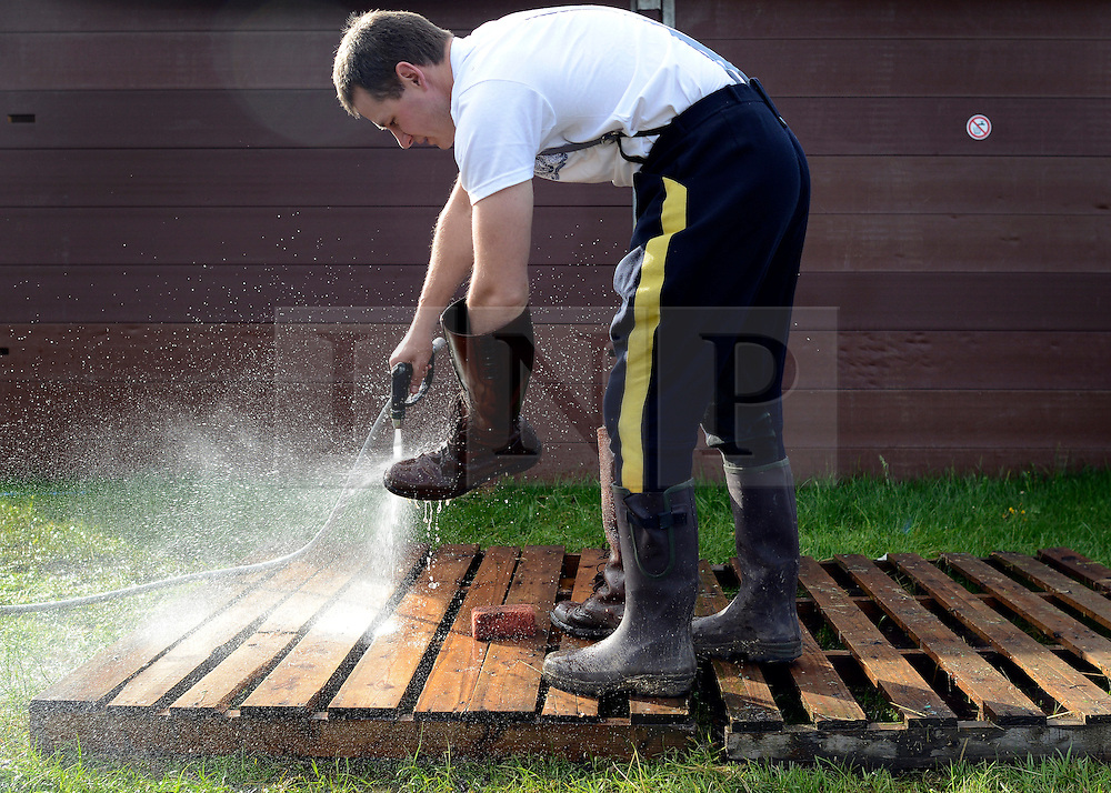 © Licensed to London News Pictures. 11/05/2012. Windsor, UK A Royal Canadian Mounted Police officer washes mud off his boots using a hosepipe drawn off the River Thames. The Royal Windsor Horse Show in Windsor, England on May 11 2012. Photo credit : Stephen Simpson/LNP