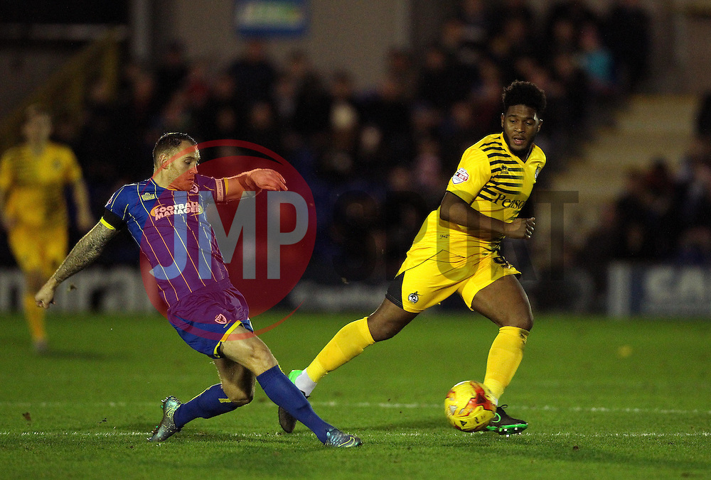 Barry Fuller of AFC Wimbledon passes the ball under pressure from Ellis Harrison of Bristol Rovers - Mandatory byline: Robbie Stephenson/JMP - 07966 386802 - 26/12/2015 - FOOTBALL - Kingsmeadow Stadium - Wimbledon, England - AFC Wimbledon v Bristol Rovers - Sky Bet League Two