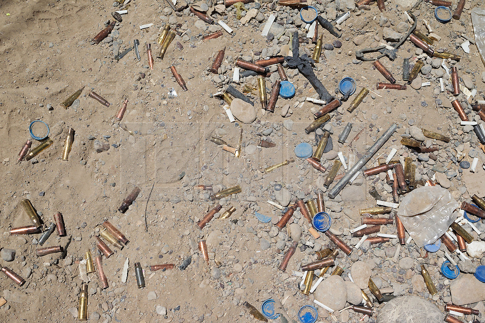 © Licensed to London News Pictures. 30/06/2014. Khanaqin, UK Khanaqin, Iraq. Cigarette butts, water bottle lids and empty rifle and machine gun cartridges litter the ground at a Kurdish peshmerga base in Jalawla, Iraq. Counted by Kurds as part of their homeland, fighting in the town of Jalawla now consists of occasional skirmishes and exchanges of fire between snipers and heavy machine guns on both sides.<br />
<br />
The peshmerga, roughly translated as those who fight, is at present engaged in fighting ISIS all along the borders of the relatively safe semi-automatous province of Iraqi-Kurdistan. Though a well organised and experienced fighting force they are currently facing ISIS insurgents armed with superior armament taken from the Iraqi Army after they retreated on several fronts. Photo credit : Matt Cetti-Roberts/LNP