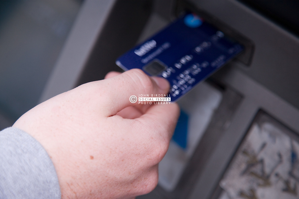 Young person withdrawing cash from an ATM,