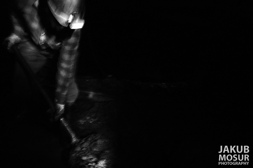 Colaminer, Stanislaw Karcz, shovels coal onto a conveyer belt 650 meters underground at the Piast Coalmine in Bierun, Poland on April 10, 2002. During the mining process ground water and coal rocks and dust combine into a thick black mud on the floor of the mine that must be constnantly removed with shovels. Photo by Jakub Mosur