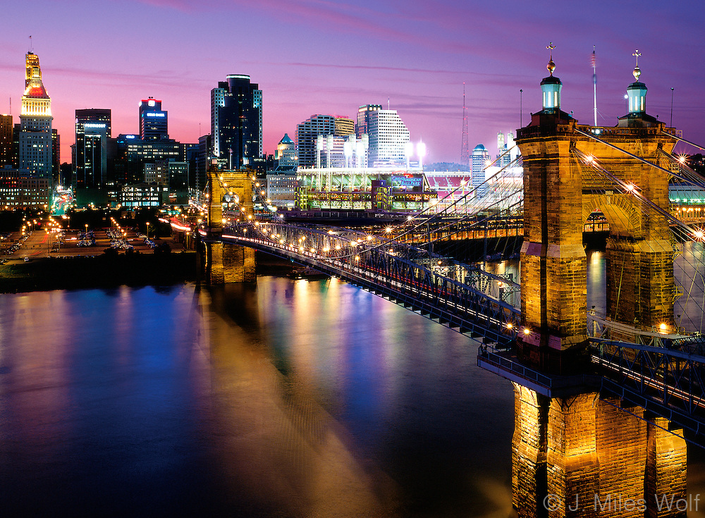 The colorful Cincinnati Skyline and the Roebling Suspension Bridge at night