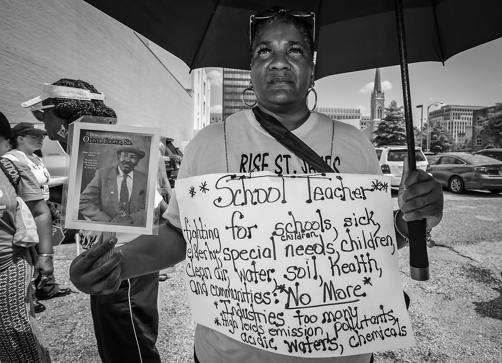 Stephanie Cooper, the Vice President of Rise St. James holding a photo of her father who died of cancer on the final day of a five day march through Louisiana's 'Cancer Alley' .. The march, held by the Coalition Against Death Alley. The Coalition Against Death Alley (CADA), is a group of Louisiana-based residents and members of various local and state organizations, is calling for a stop to the construction of new petrochemical plants and the passing of stricter regulations on existing industry in the area that include the groups RISE St. James, Justice and Beyond, the Louisiana Bucket Brigade, 350 New Orleans, and the Concerned Citizens of St. John. Louisiana’s Cancer Alley, an 80-mile stretch along the Mississippi River, is also known as the “Petrochemical Corridor,” where there are over 100 petrochemical plants and refineries .