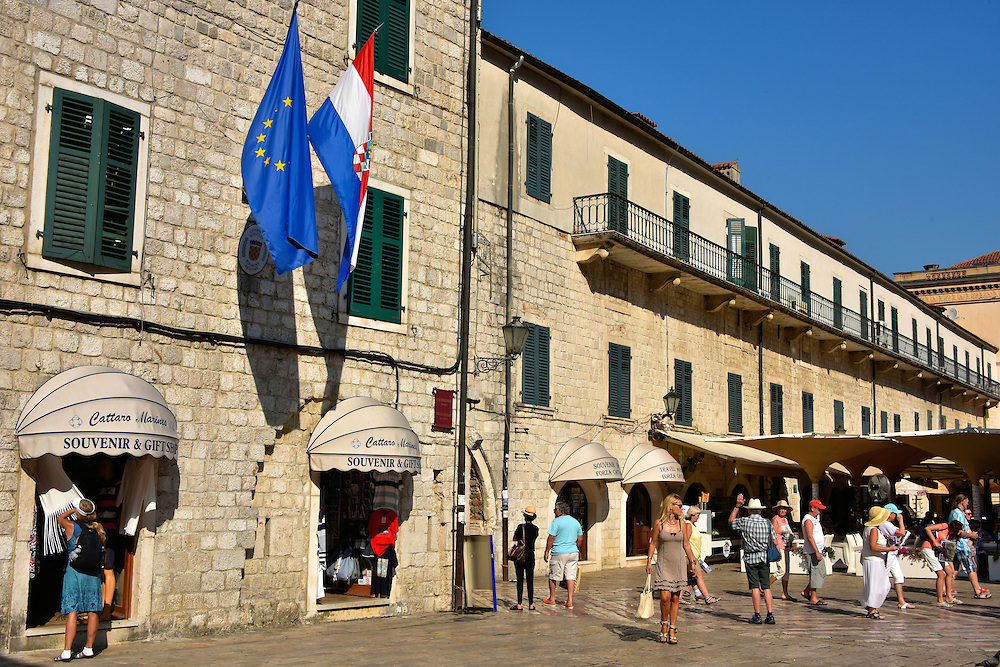 Arms Square in Kotor, Montenegro<br />
After passing through Kotor’s main gate you enter the Trg od Oružja or Arms Square. On the right in this photo is the Ducal Palace. This Renaissance building was designed as the residence for the Venetian Provost. It was a warehouse for munitions which is how the plaza got its name. Today the lower level is filled with shops, a restaurant and part of the Hotel Cattaro. On the left was the Tower of the City Guard from the 13th until the 20th century.