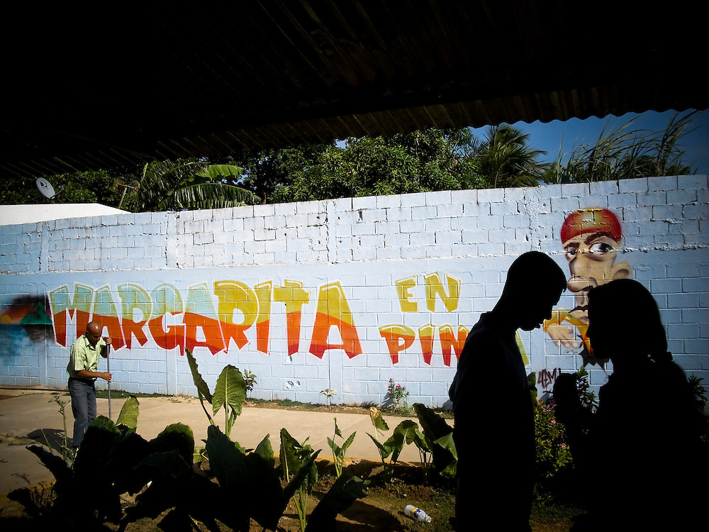A prisoner says goodbye to his girlfriend at the end of visiting hours inside San Antonio prison in Porlamar, Venezuela. The prison on Margarita Island houses 2,000 inmates, and is known amongst criminals as the prime place to serve time. It is unofficially run by convicted drug trafficker, Teófilo Rodríguez, who said in an interview that his goal was to create an atmosphere inside the prison as a, "peaceful party". During his reign at the prison, Rodríguez has constructed four swimming pools, a cockfighting arena, hosts hip hop concerts and dances at the prison discothèque, and has built over 200 private rooms where prisoners may enjoy conjugal visits three times a week.